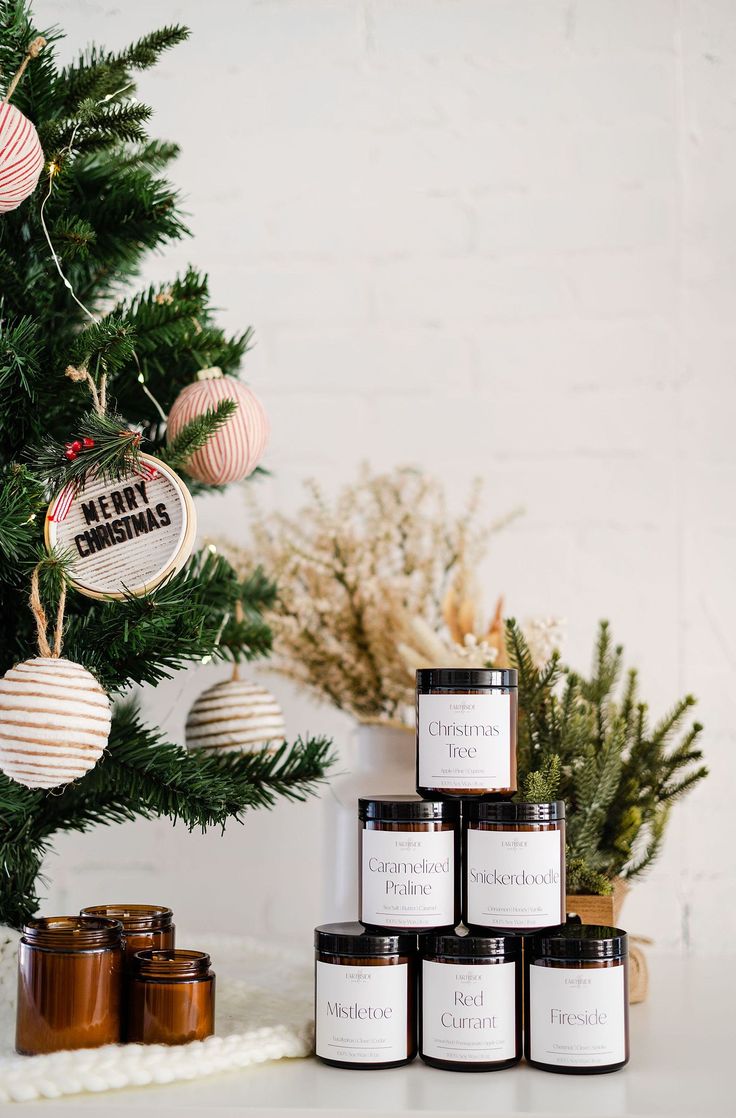 some candles are sitting in front of a christmas tree