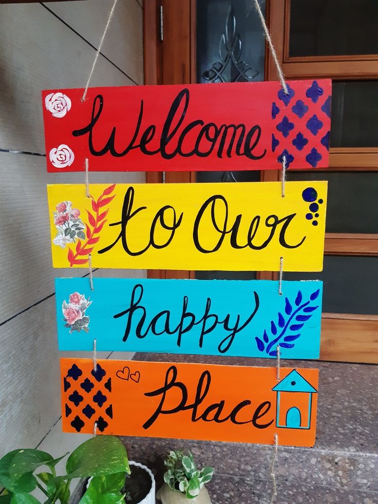 a sign that says welcome to our happy place hanging from a door way with potted plants