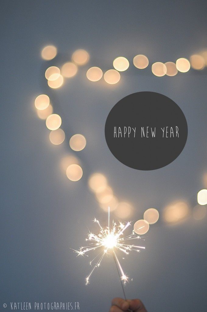 a person holding a sparkler in their hand with the words happy new year written on it