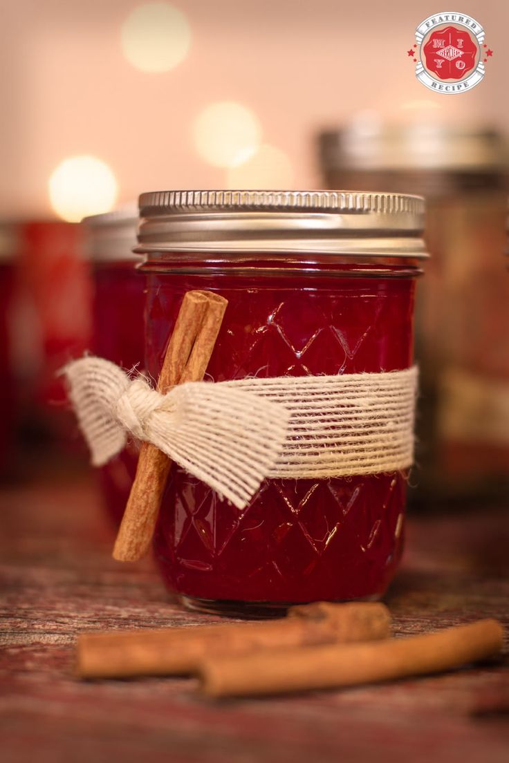 a glass jar filled with red liquid and cinnamon sticks