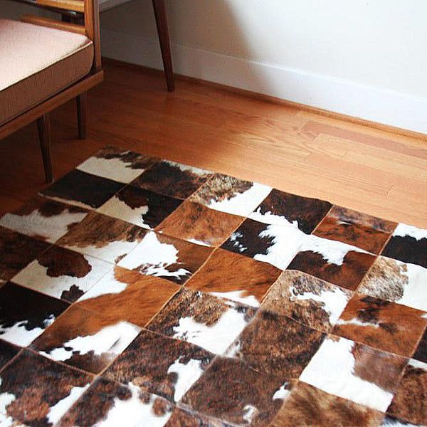 a brown and white rug sitting on top of a wooden floor next to a bench