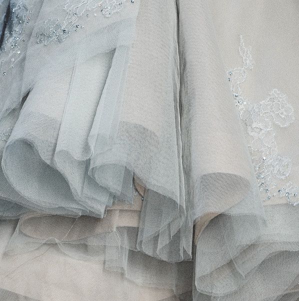 there is a close up view of a wedding dress on the bed with it's ruffles