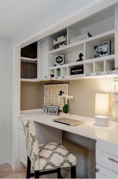 a white desk with a chair next to it and some shelves on the wall behind it