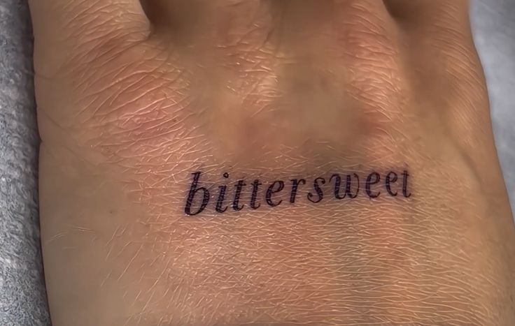 the word bittersweet written on someone's wrist