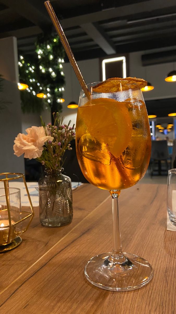 a glass filled with liquid sitting on top of a wooden table