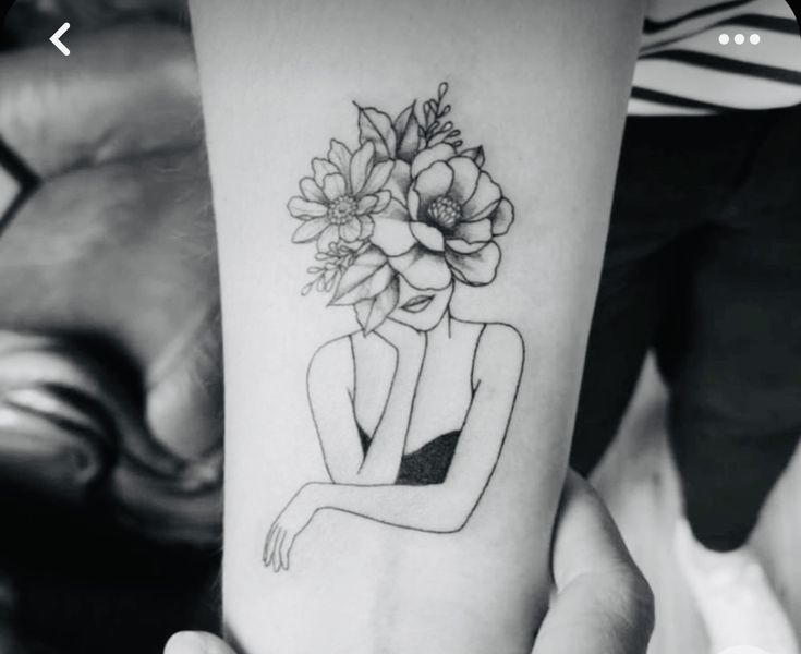 a woman's arm with a flower tattoo on it