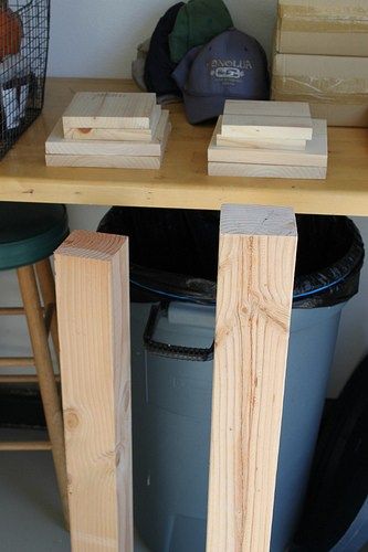 several pieces of wood sitting on top of a wooden table next to a trash can