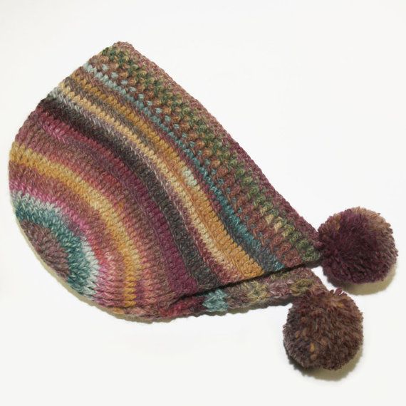 a multicolored knitted hat with pom - poms on the side