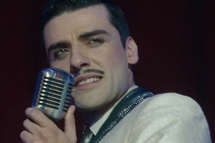 a man with a moustache holding a microphone