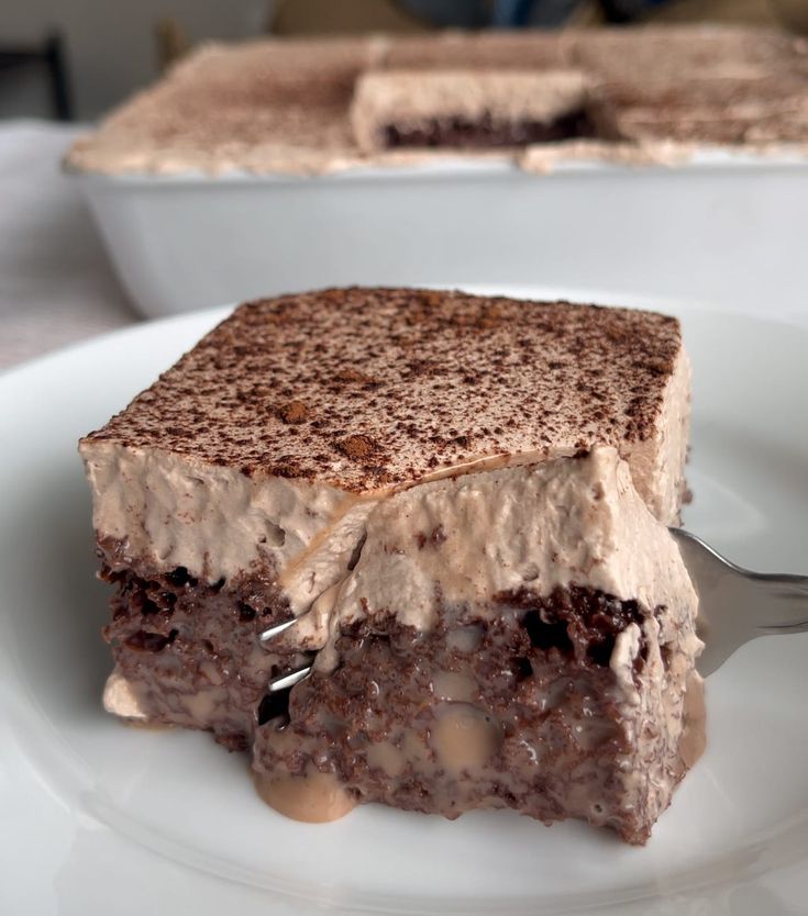 a close up of a piece of cake on a plate with a fork in it