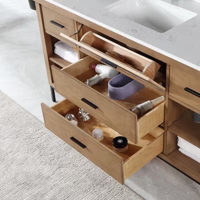 a bathroom vanity with two drawers that are open to show the sink and toiletries