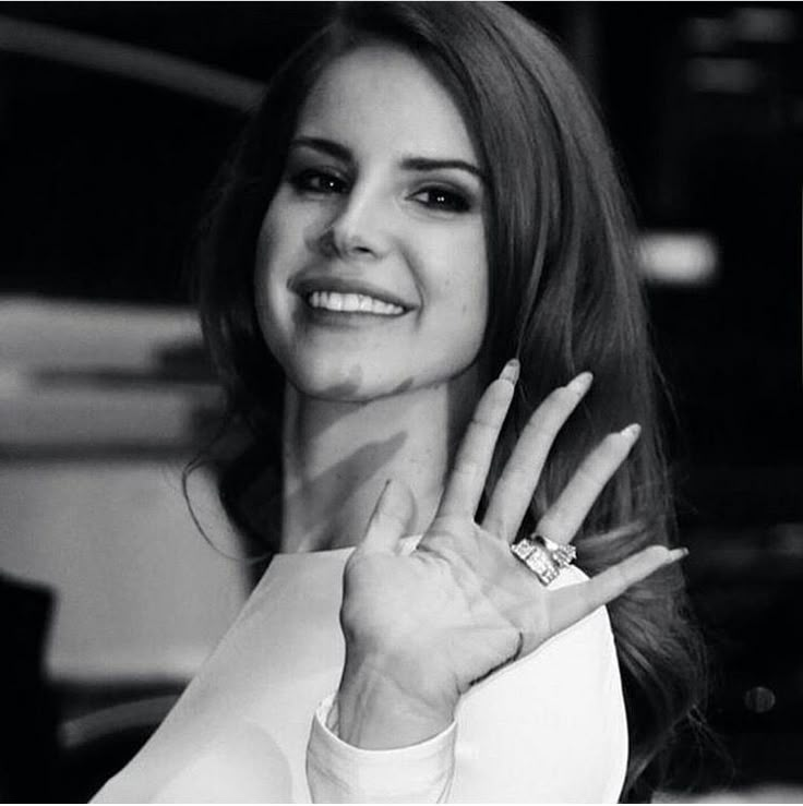 a black and white photo of a woman holding her hand up to the side with both hands