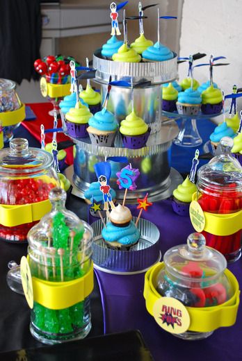 there are many cupcakes and candy in the containers on the table with them