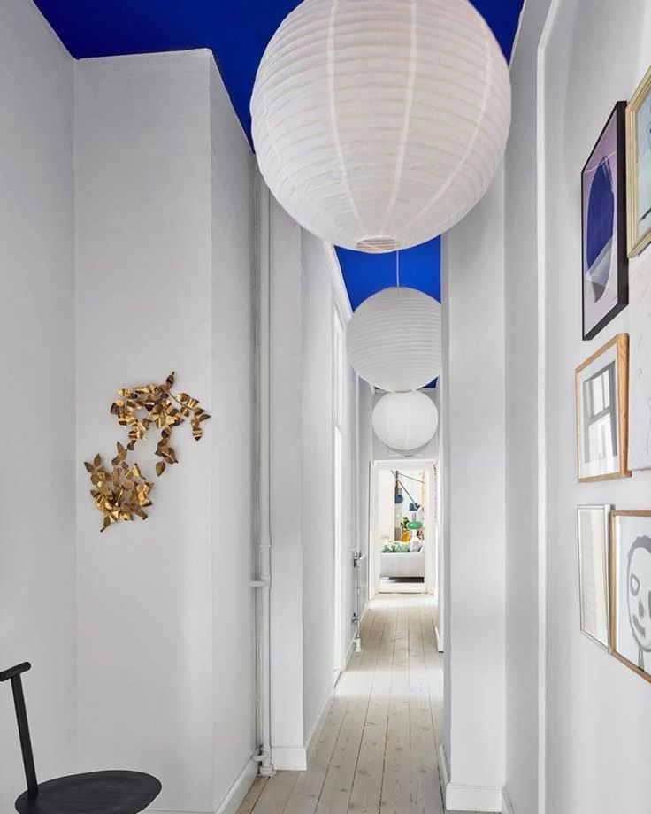 a hallway with white walls and blue ceiling