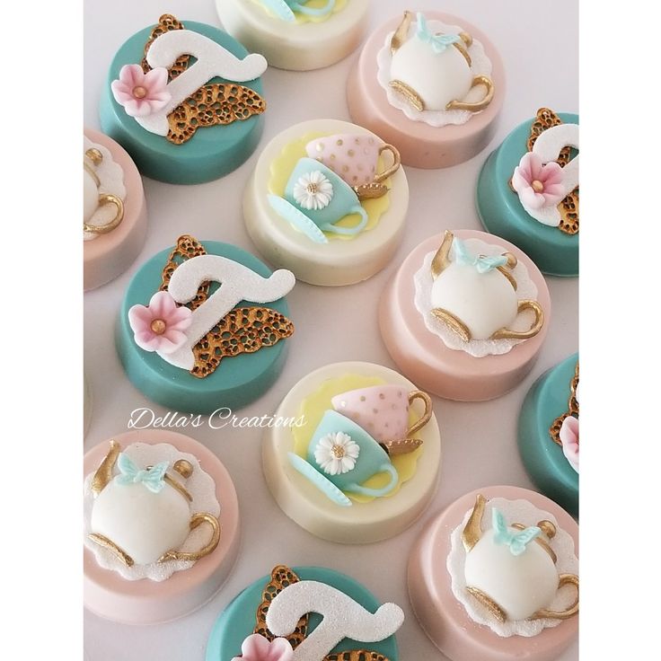 there are many cupcakes decorated like animals and tea cups on top of each other