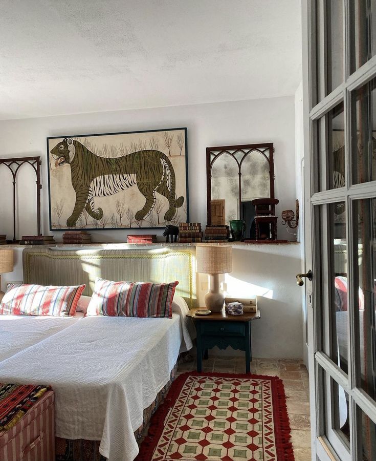 a bedroom with two beds and paintings on the wall