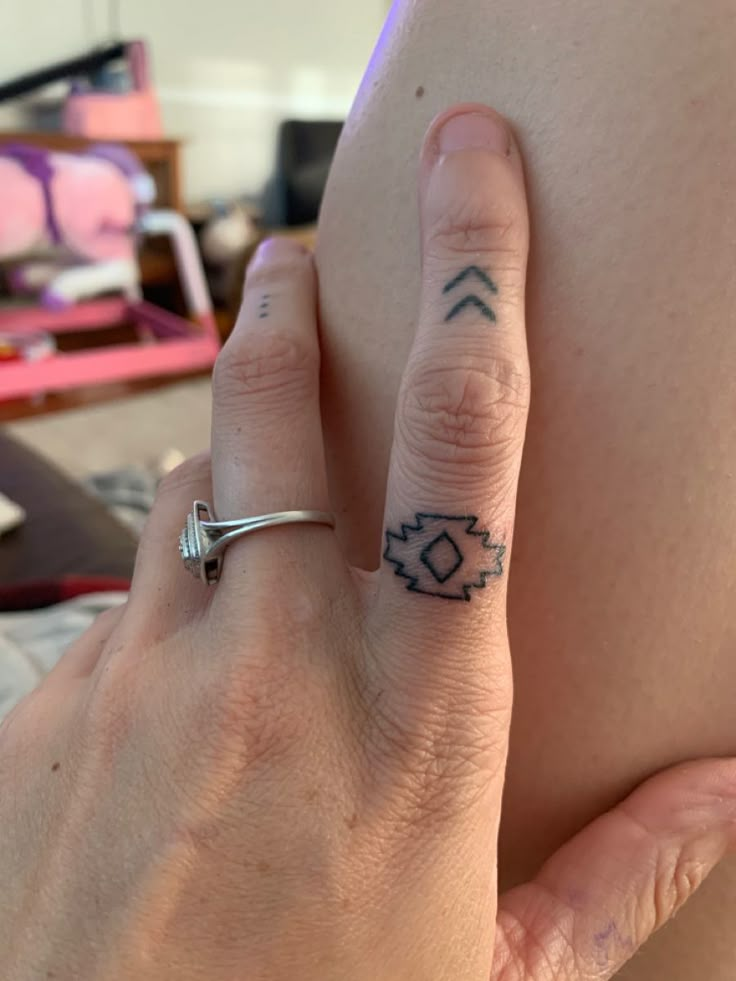 a woman's hand with a small tattoo on her left side and an arrow in the middle