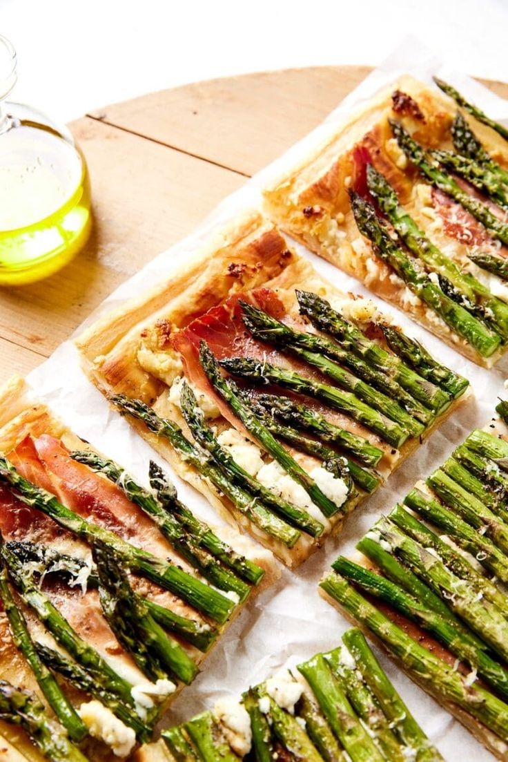 asparagus and prosciutto flatbread pizzas on a cutting board