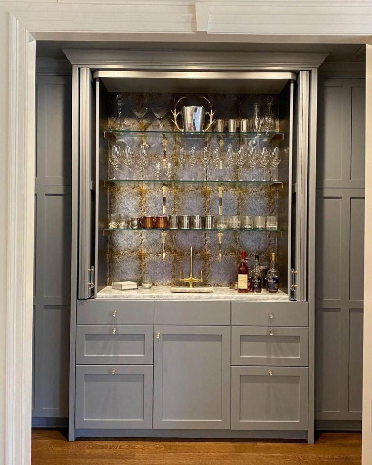 a cabinet with many glasses and bottles on it