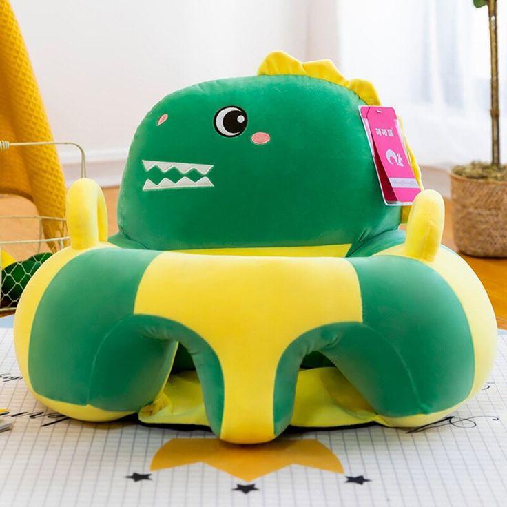 a green and yellow stuffed animal sitting on top of a table