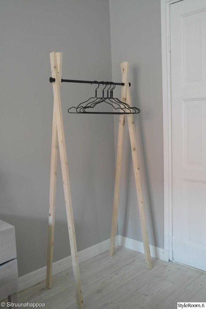 two wooden clothes hangers in front of a gray wall with a white closet door