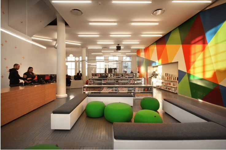 the interior of a modern library with colorful walls and floor to ceiling bookshelves