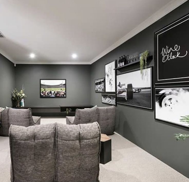 a room with two recliners and pictures on the wall above them, along with a coffee table