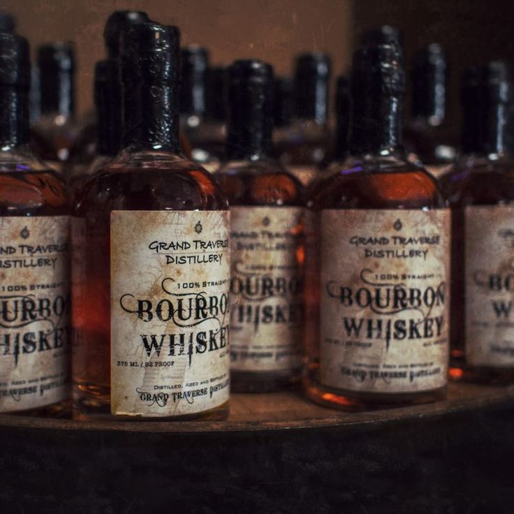 bottles of bourbon whiskey are lined up on a shelf