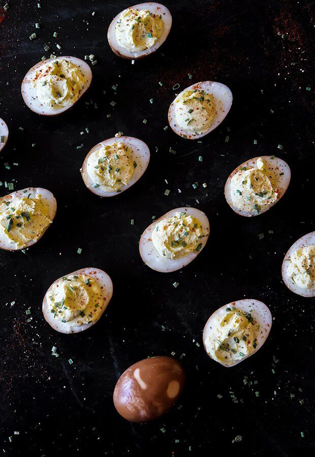 an assortment of deviled eggs on a black surface