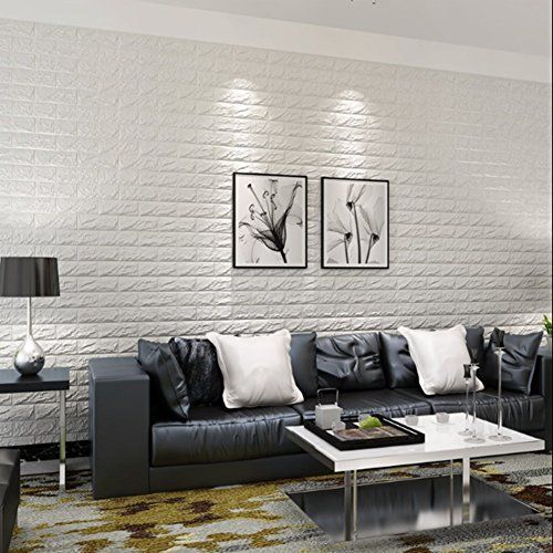 a living room with white brick walls and black leather couches, coffee table and lamp