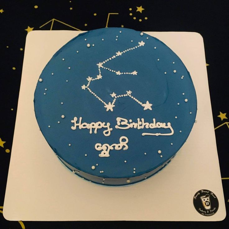 a blue birthday cake with the zodiac sign on it's side and happy birthday written in white frosting