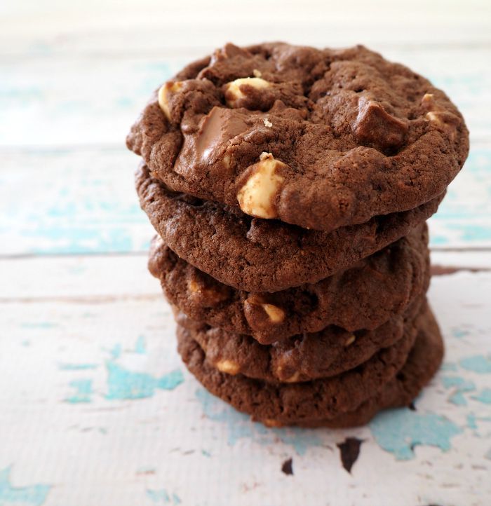 triple choc cookies stacked on top of each other in front of the camera with text overlay