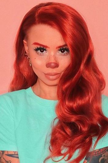 a woman with long red hair and piercings