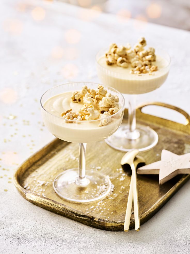 two desserts on a tray with spoons and utensils