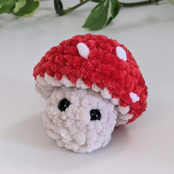 a small stuffed animal with a red hat on it's head, sitting next to some flowers