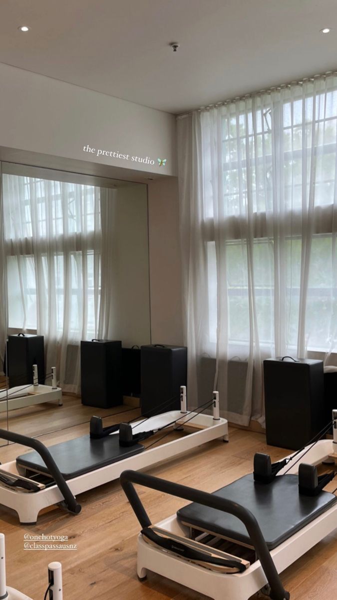 an empty gym room with treadmills and mirrors