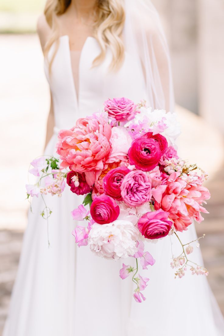 a bride holding a bouquet of pink and white flowers