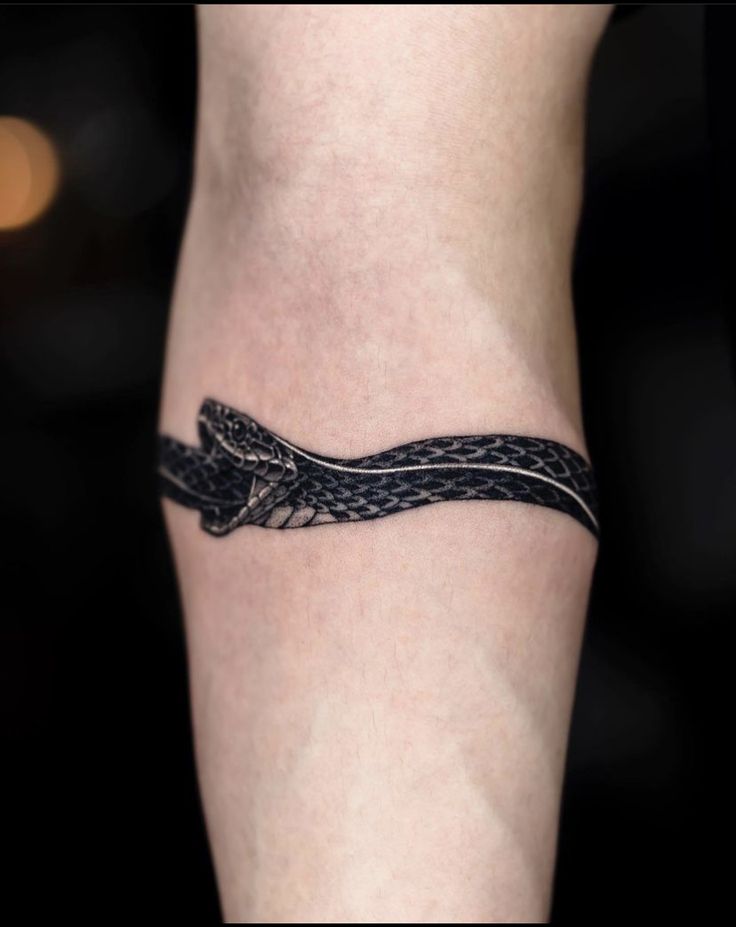 a tattoo on the leg of a woman with a snake crawling through it's skin