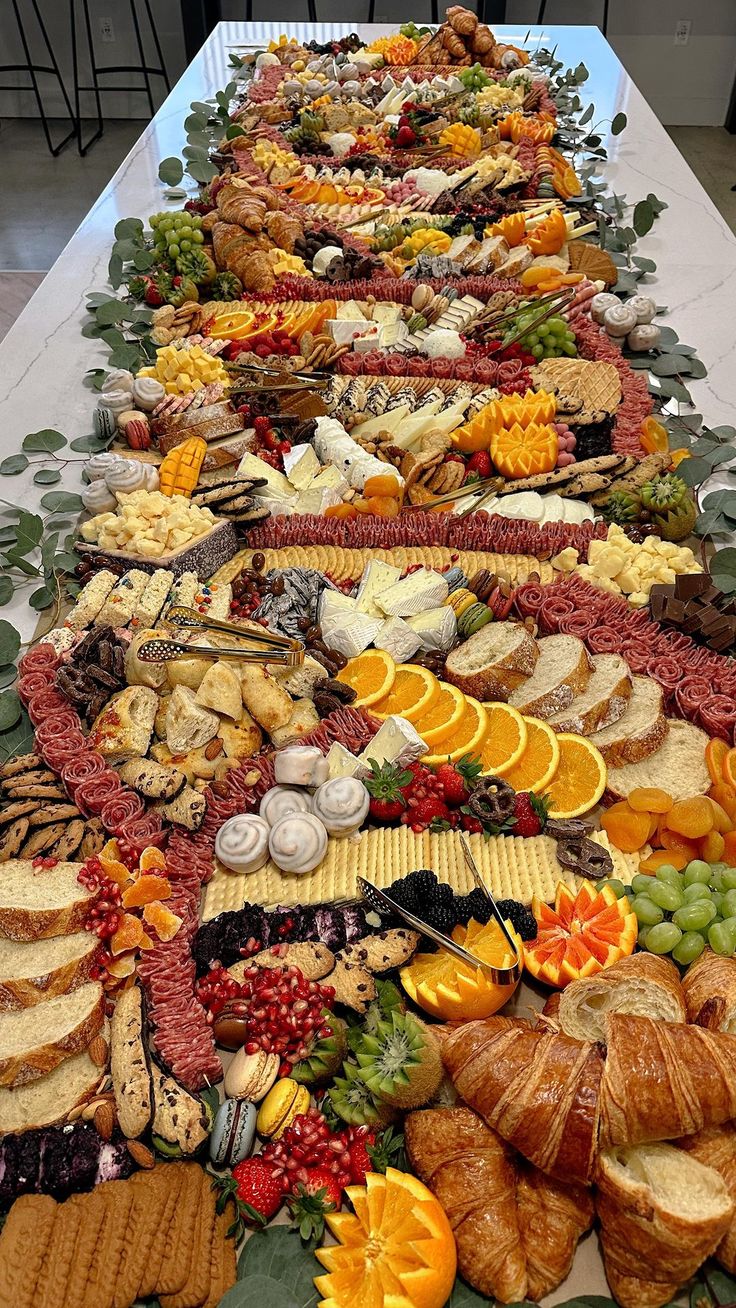 a long table filled with lots of different types of food on top of each other