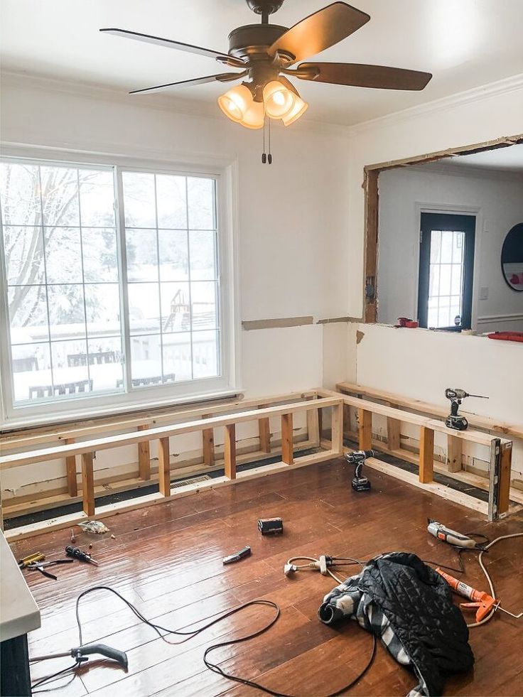 an empty room is being remodeled with wood flooring and ceiling fan in the corner