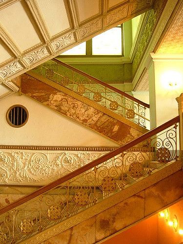 an ornate stair case in the middle of a building with green and gold paint on it