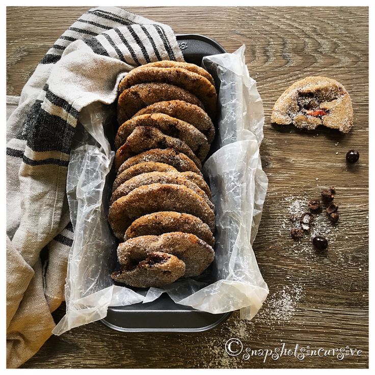 a tray filled with cookies sitting on top of a wooden table next to a napkin