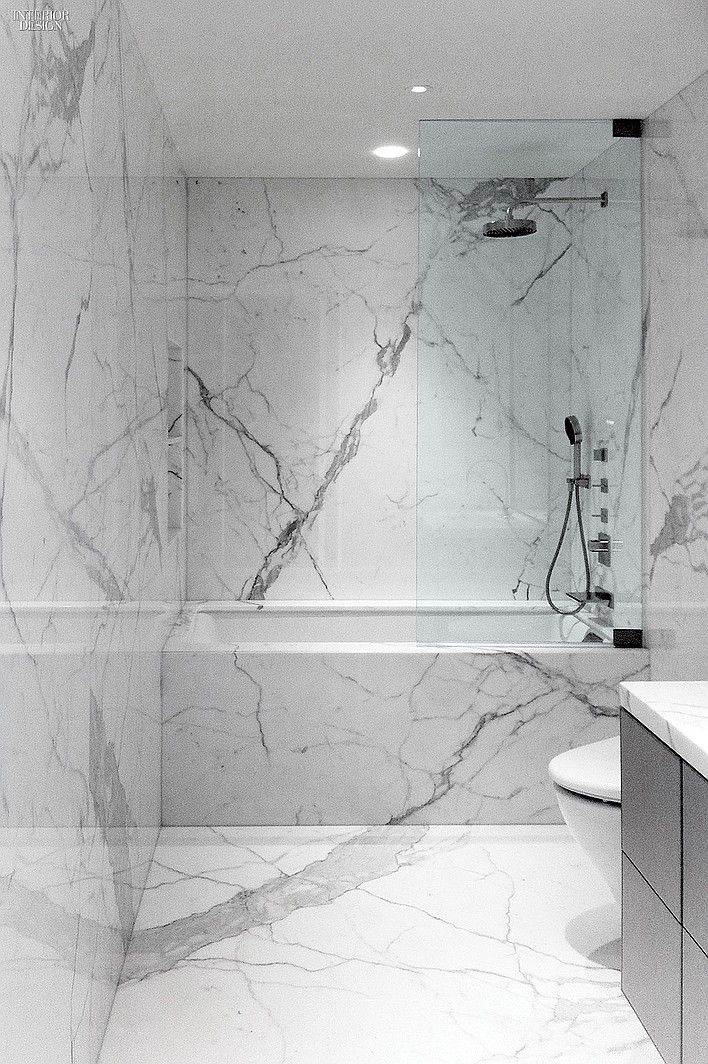 a bathroom with marble walls and flooring in black and white colors, including the shower