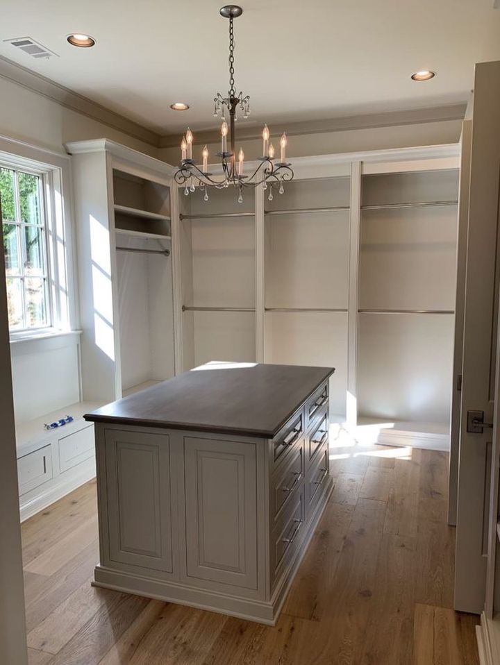 a kitchen with an island in the middle and built - in cabinets on both sides