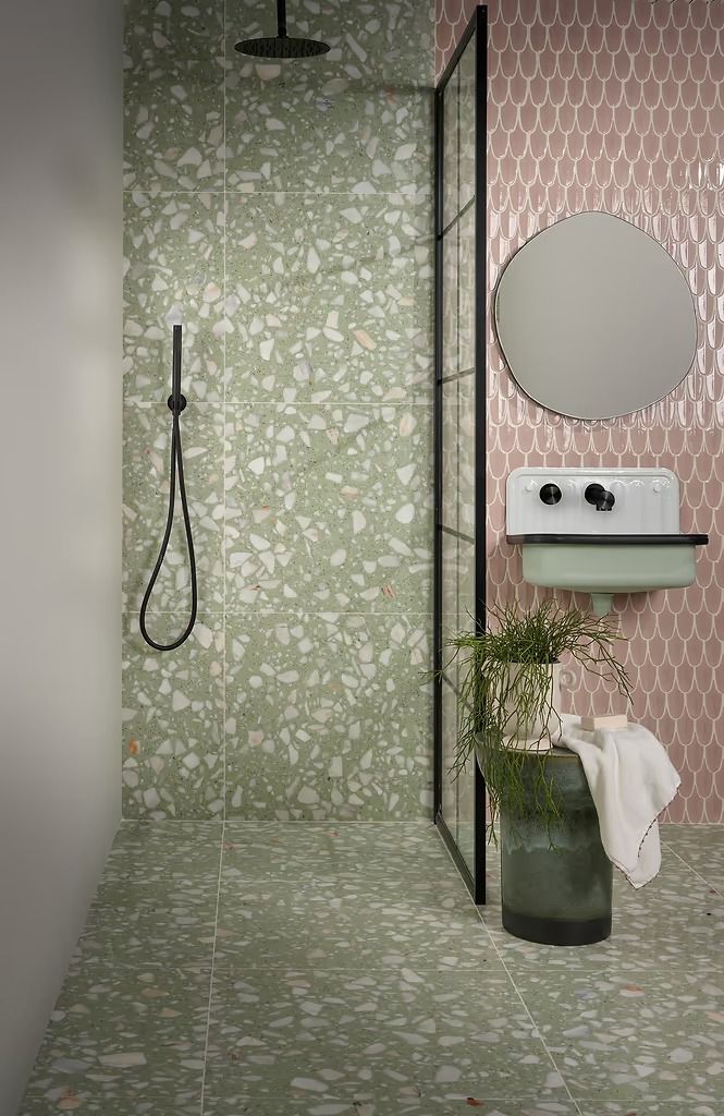 a bathroom with a sink, mirror and shower head in it's center wall