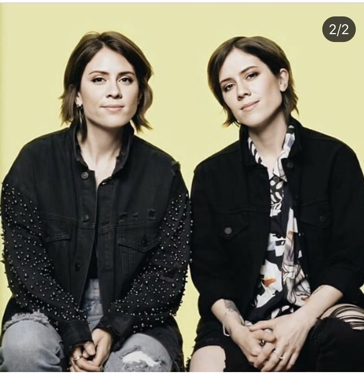 two women sitting next to each other in front of a yellow background