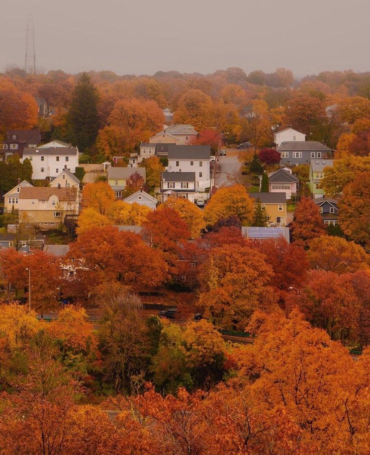 an autumn scene with houses and trees in the foreground