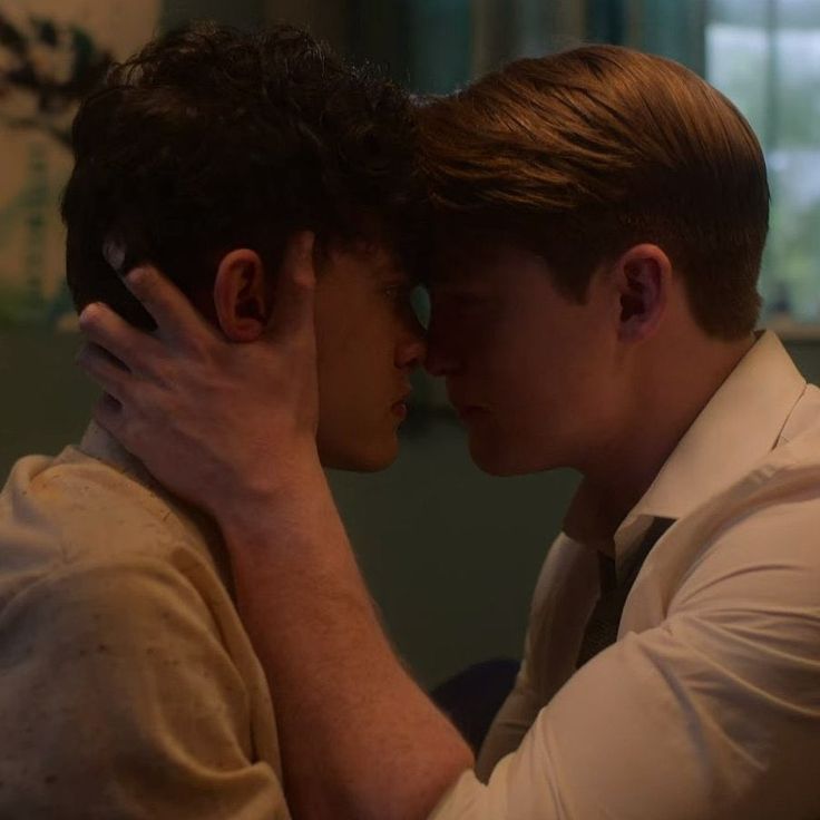 two men are kissing each other in the dark