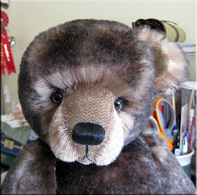 a brown teddy bear sitting on top of a desk