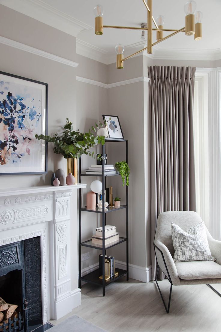 a living room filled with furniture and a fire place next to a window covered in curtains